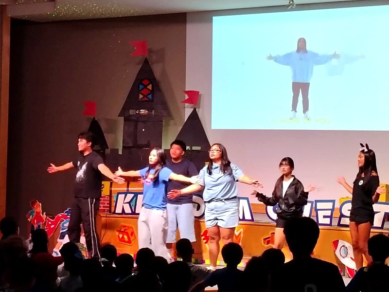 Youth leading songs on stage at Vacation Bible School